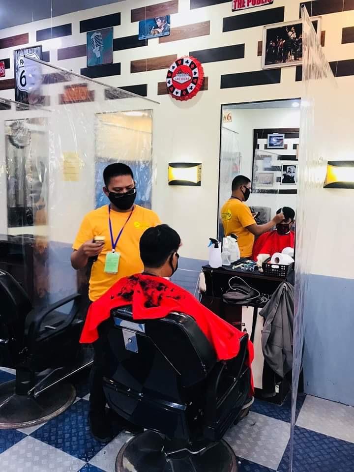 Barber and client wearing facemasks in a barbershop  in a mall in Region 9