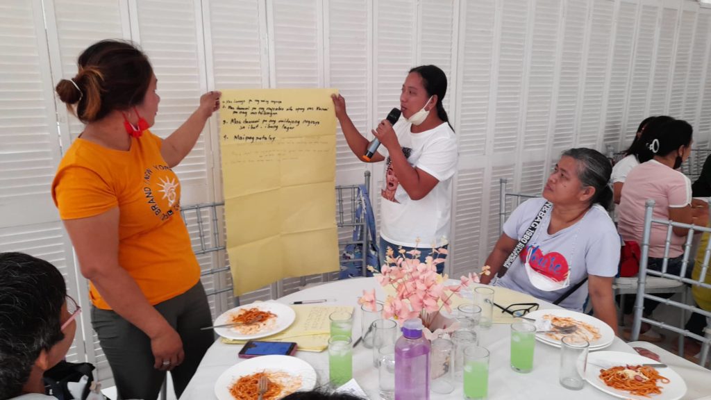 in photo: two women presenting their output.