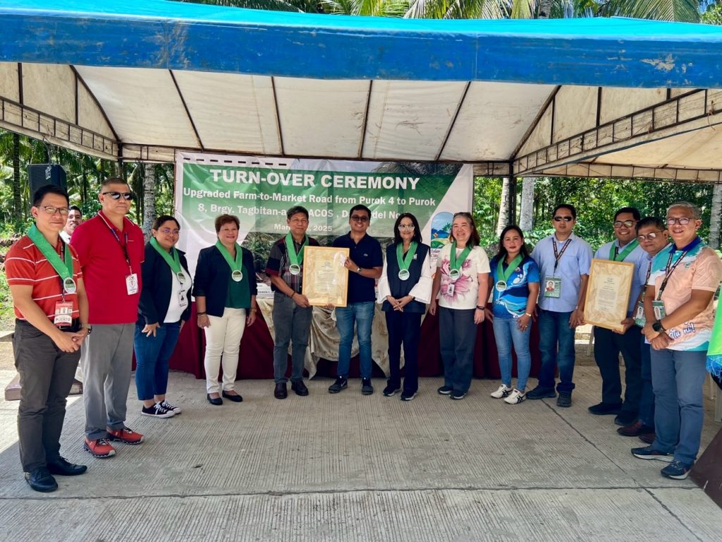 A group of individuals posing for a photo at the official turnover ceremony of the Farm-to-Market Road. DTI-ROG Undersecretary Lantayona stands seventh from the right.