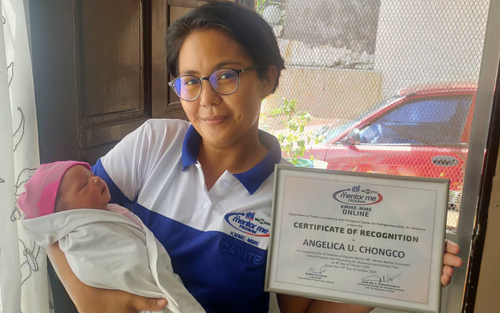 Angelica Chongco shows her KMME Certificate of Recognition while carrying her baby
