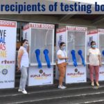 Women standing in front of testing booths
