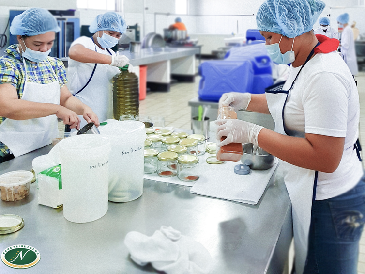 Nene Prime Foods' employees busy filling bottles with oil and chili