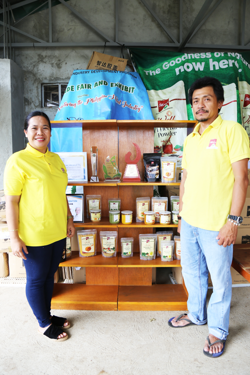 Almira Silva and her husband standing next to a shelf of Mira’s Turmeric Products.