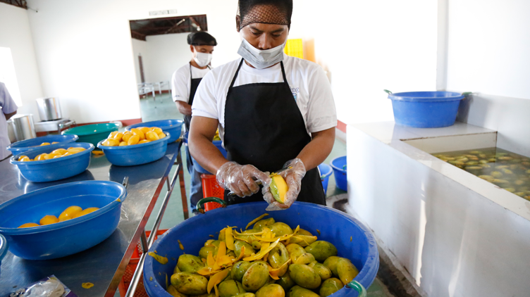 Mango King employee peeling the mangoes
