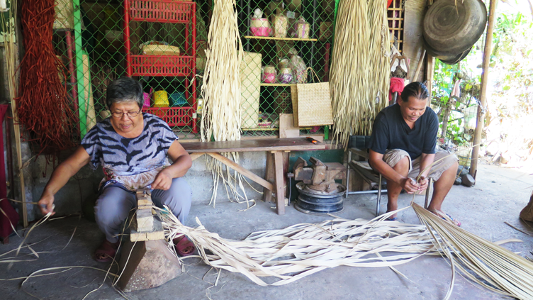 Employees of Tamayo's Handicrafts, source of Buttons 'n Things' fabric, processing dried buri into raffia.