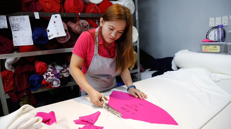 An employee of ATE cutting out fabric according to a pre-made pattern