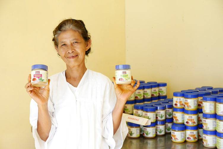 A member of Mother Ignacia Women’s Association holding up two jars of powdered turmeric