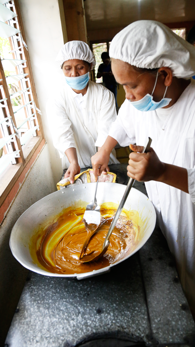 Members of MIWA ladling turmeric paste on a pan