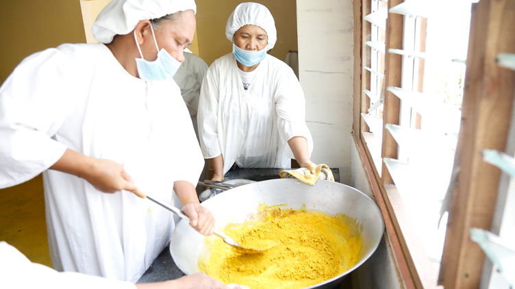 Members of MIWA scooping up turmeric powder
