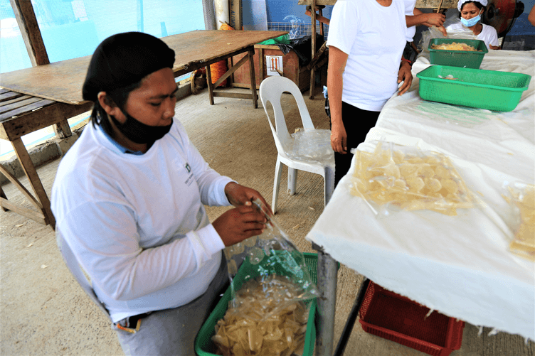 A member of the Dapitan Cassava Growers and Processors Association packaging the cassava chips