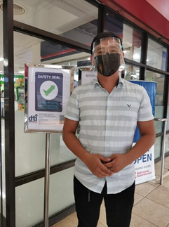 Assistant Store Manager Gerald Gua-an of Robinsons Supermarket in Laviña Park, Valencia City, Bukidnon proudly shows the supermarket’s Safety Seal. The branch is the first supermarket in Northern Mindanao to receive the seal.